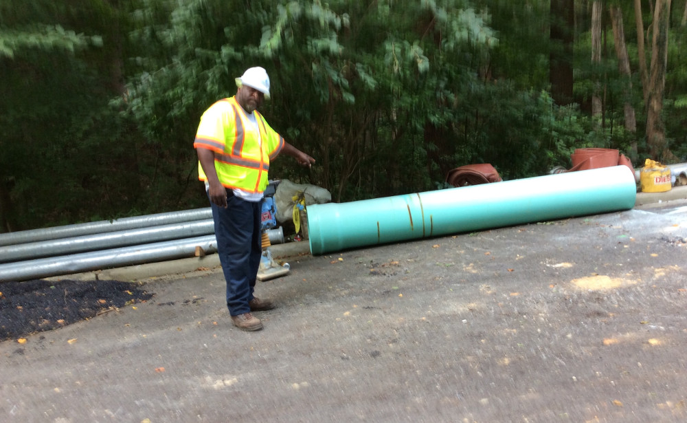 DC Water's John Crowder points to an 18-inch PVC pipe from which a piece was cut. (photo by David Jonas Bardin)
