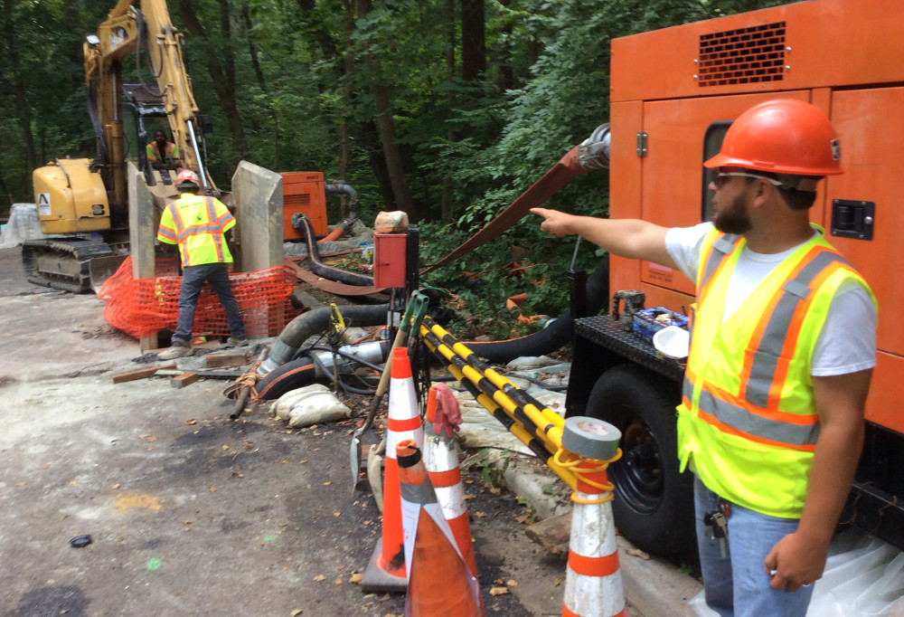 Noe Salinas of Anchor Construction points out the work pit, two bypass hoses and two bypass pumps. (photo by David Jonas Bardin)