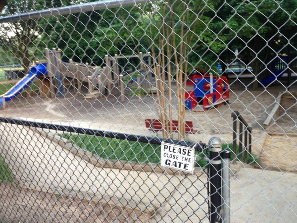 The Forest Hills playground on June 9th, the first day of demolition. Seen here: The construction fence. Not seen (anymore): The toys and wood chips. 
